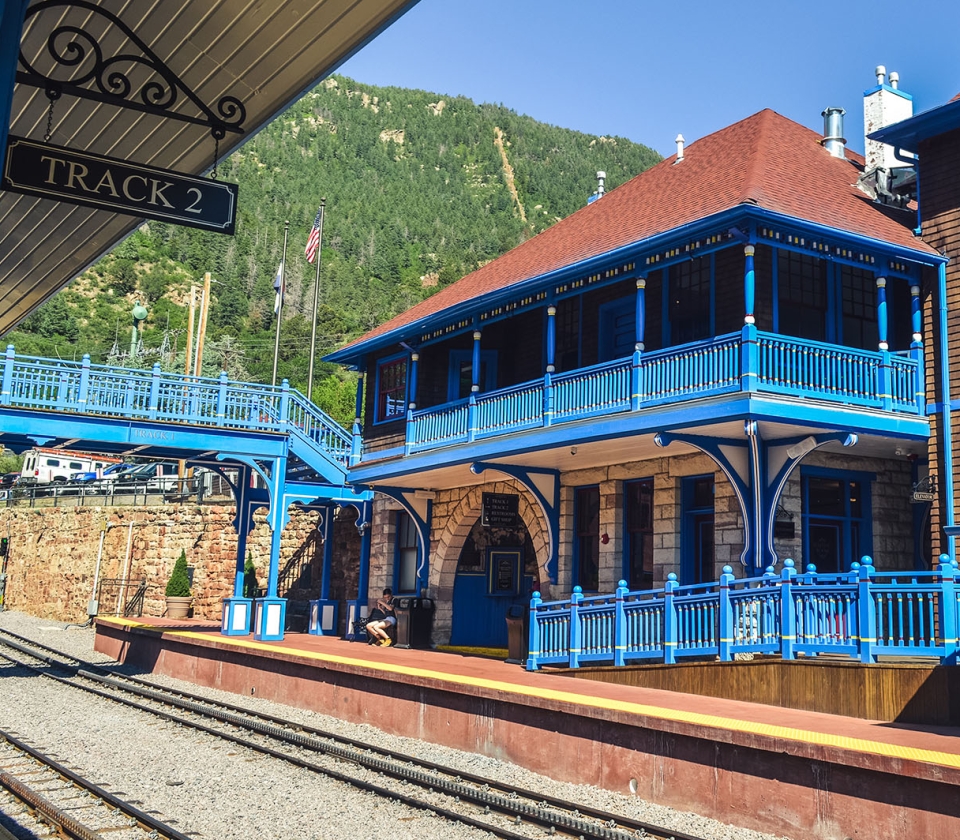 Blue railings and building alongside empty train tracks