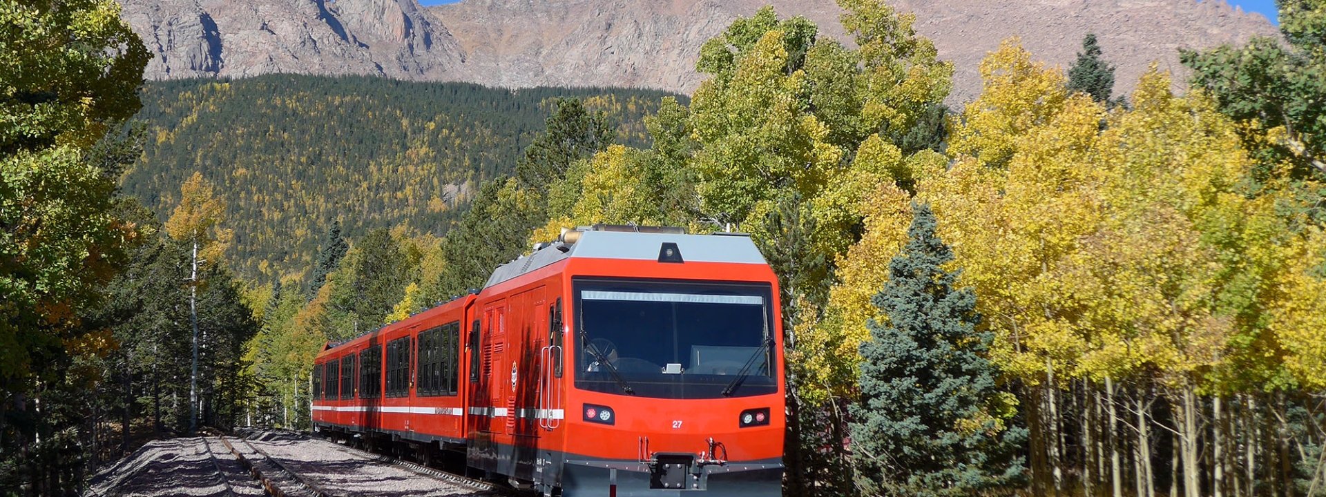 Train on tracks with mountain views