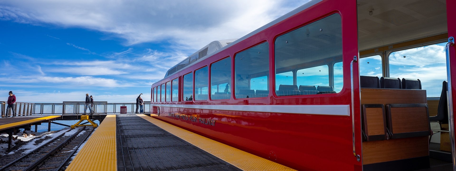 Couple taking selfie on mountain next to red train on tracks