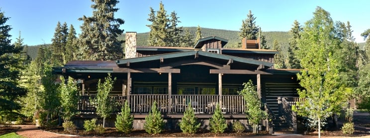 lodge with mountain backdrop and green grass