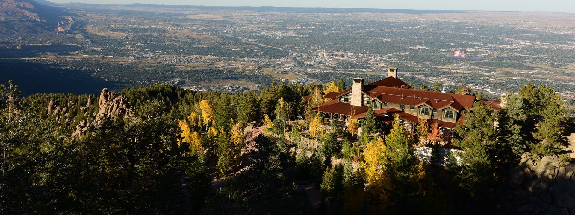 Building on mountain at sunset with blue skies and American flag flying
